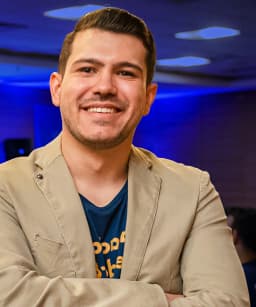 Lin Zeri, founder of Etuos, smiling with his arms crossed at a packed event