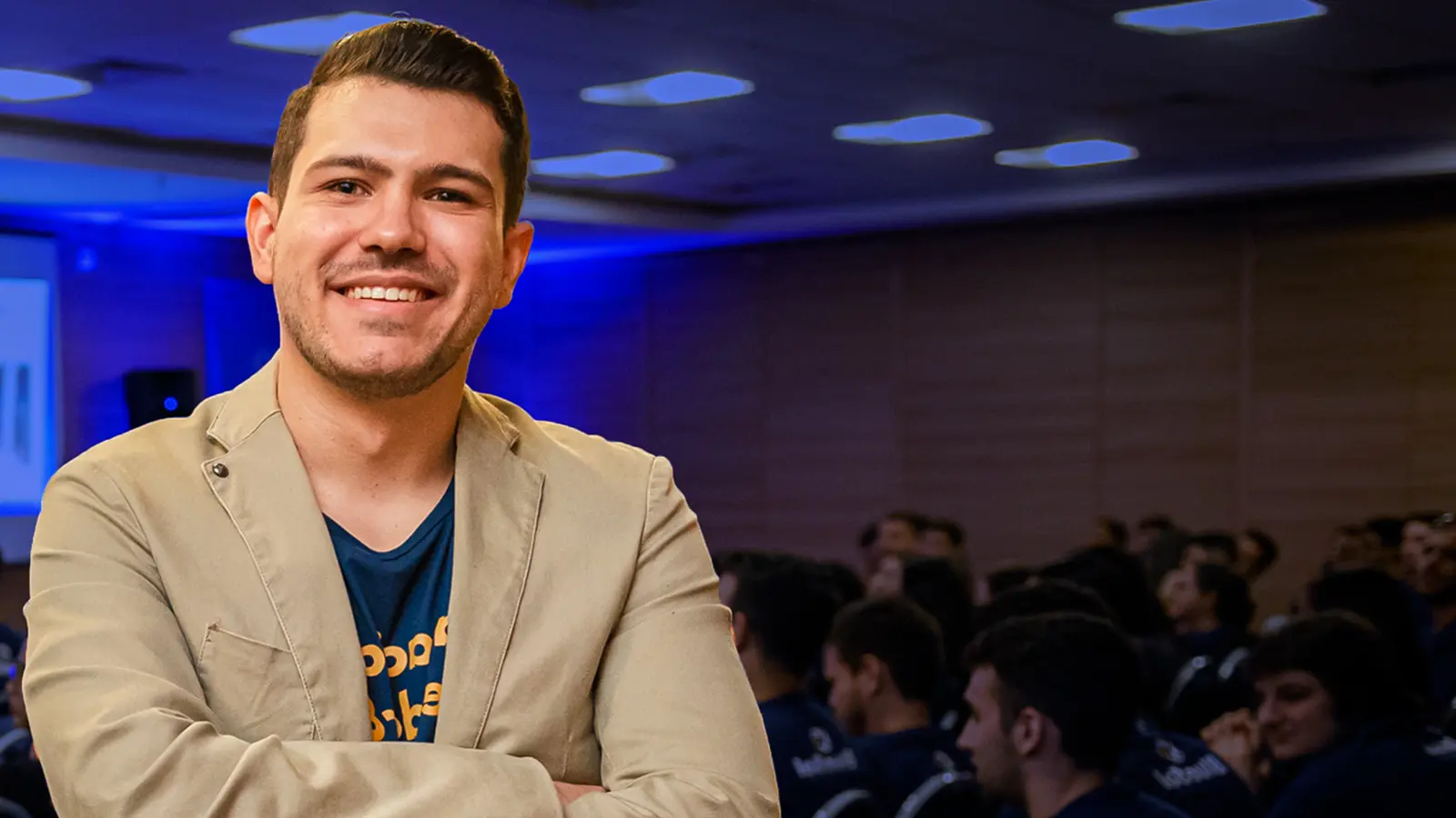 Lin Zeri, founder of Etuos, smiling with his arms crossed at a packed event